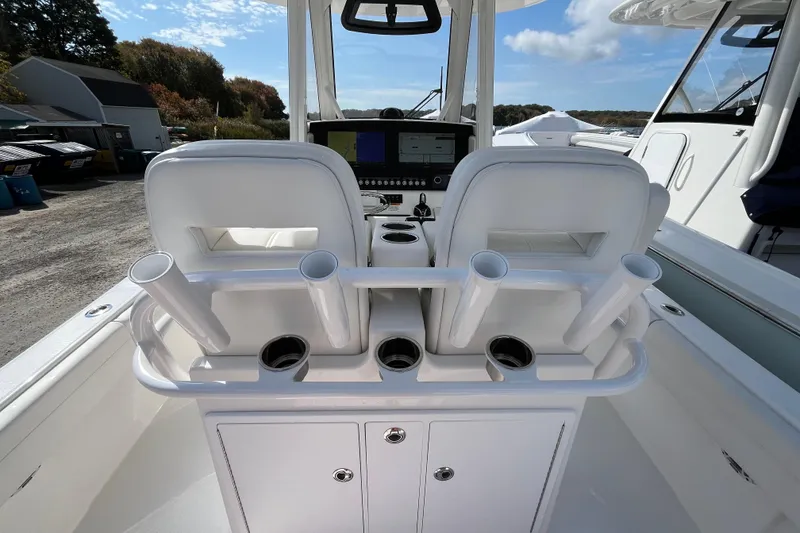 Slide: The Image of 2023 Regulator 28 boat cockpit with dual seats and rod holders under a clear sky. - 51