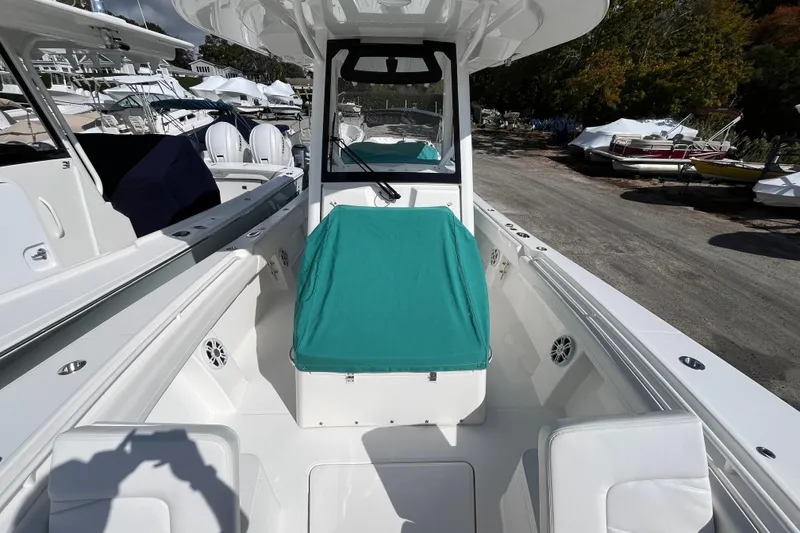 Slide: The Image of 2023 Regulator 28 boat interior with teal cover, docked among other boats. - 56