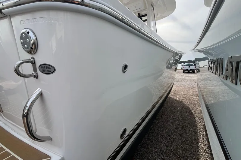 Slide: The Image of 2023 Regulator 28 boat, side view with chrome details, parked on gravel. - 7