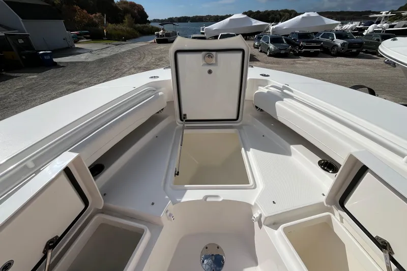 Slide: The Image of 2023 Regulator 28 boat interior with open storage compartments, docked near water. - 9