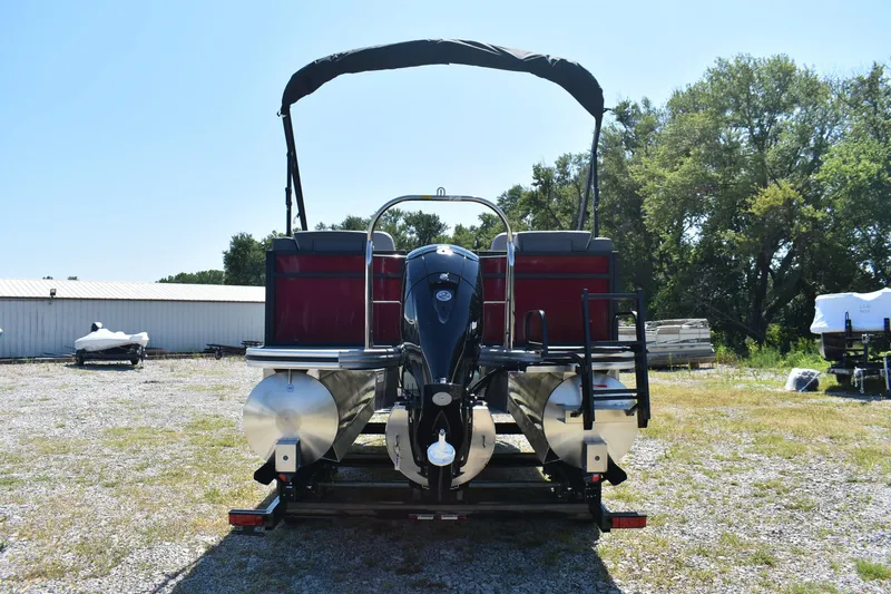 Slide: The Image of 2025 Lowe LS 210 WT pontoon boat with canopy, parked outdoors on gravel. - 20