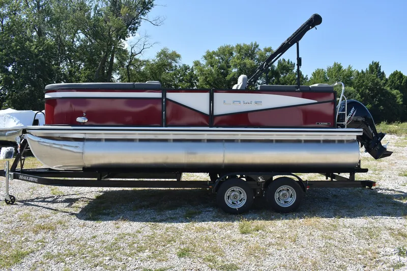 Slide: The Image of 2025 Lowe LS 210 WT pontoon boat on trailer, parked outdoors. - 6