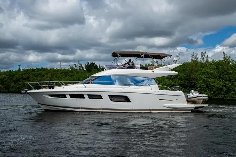 Slide: The Image of 2012 Prestige Flybridge yacht cruising on a river under cloudy skies. - 11