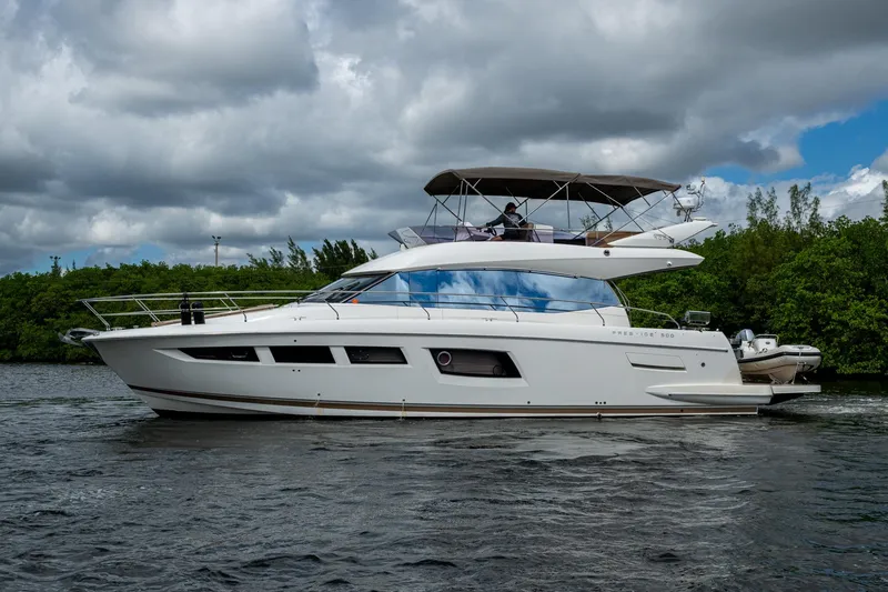 Slide: The Image of 2012 Prestige Flybridge yacht cruising on a scenic waterway under cloudy skies. - 14