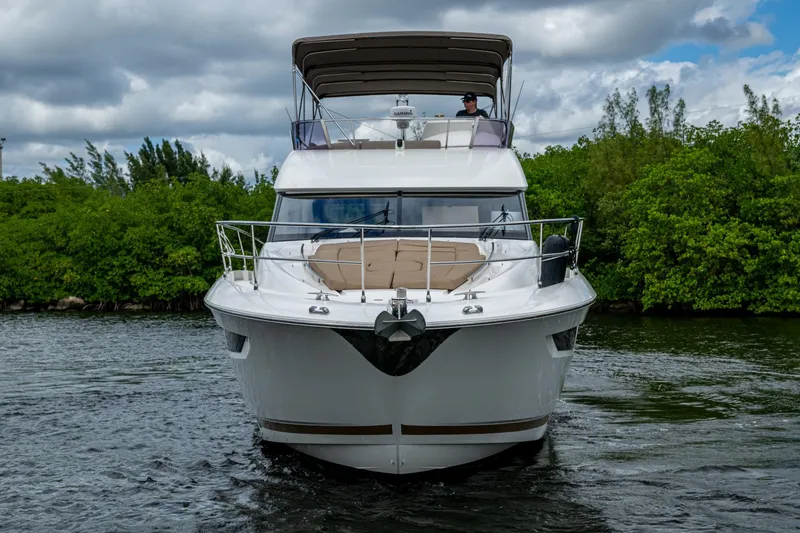 Slide: The Image of 2012 Prestige Flybridge yacht cruising on a scenic waterway with lush greenery. - 17