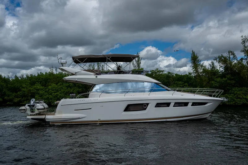 Slide: The Image of 2012 Prestige Flybridge yacht cruising on a river under cloudy skies. - 22