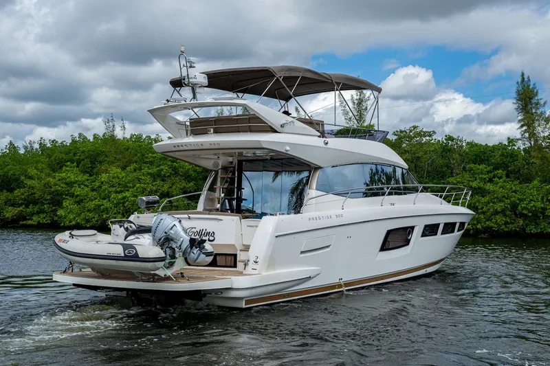 Slide: The Image of 2012 Prestige Flybridge yacht cruising on a scenic waterway with lush greenery. - 23