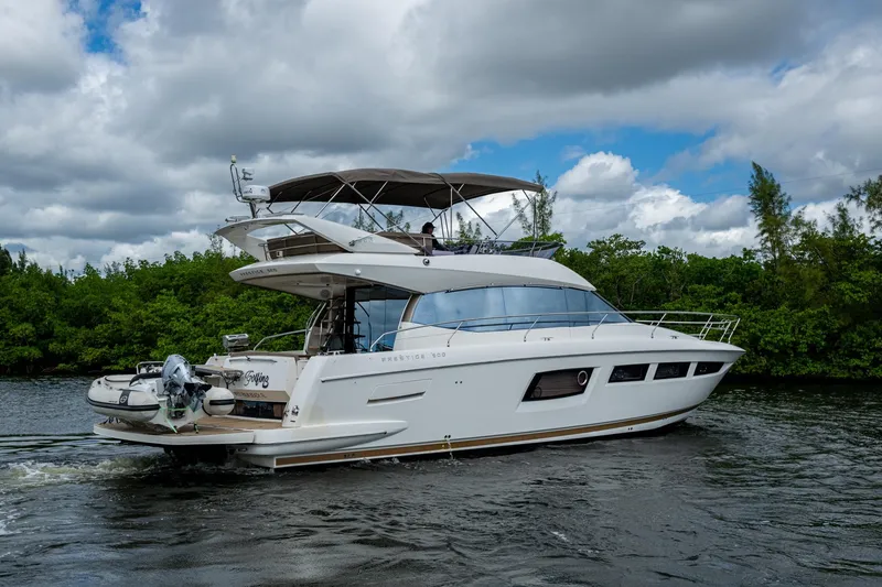 Slide: The Image of 2012 Prestige Flybridge yacht cruising on a river under cloudy skies. - 24