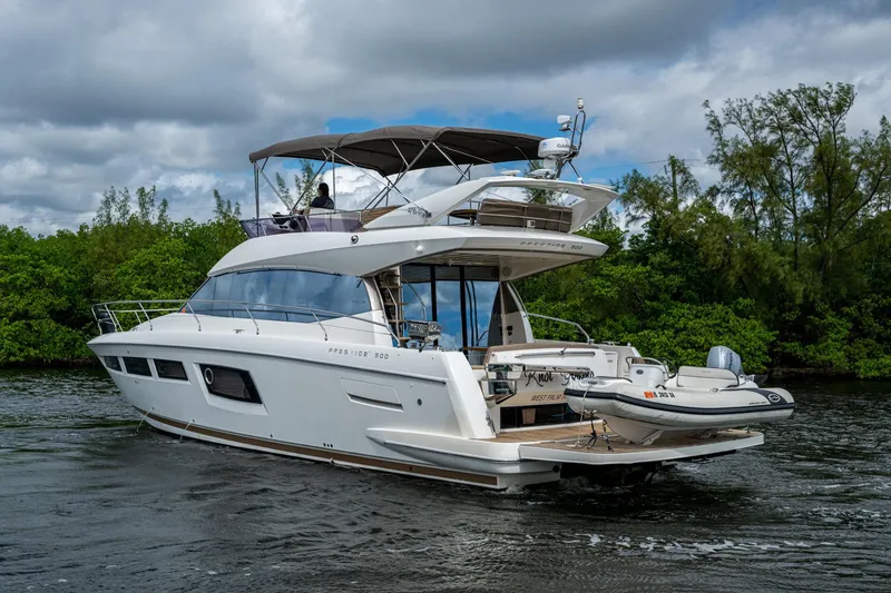 Slide: The Image of 2012 Prestige Flybridge yacht cruising on a river with lush greenery in the background. - 27