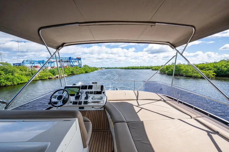 Slide: The Image of 2012 Prestige Flybridge yacht helm with river view, featuring modern navigation equipment. - 38