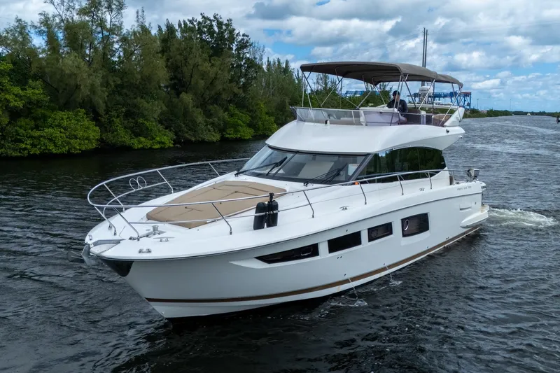 Slide: The Image of 2012 Prestige Flybridge yacht cruising on a scenic waterway with lush greenery. - 7