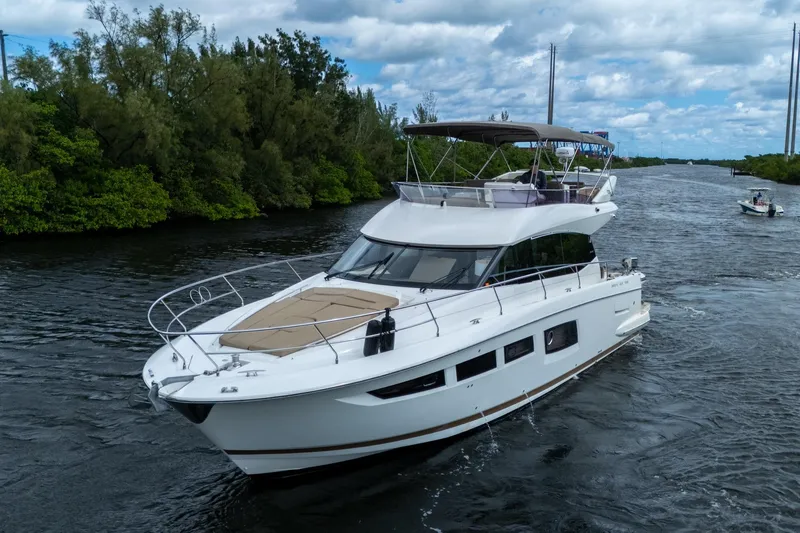 Slide: The Image of 2012 Prestige Flybridge yacht cruising on a scenic waterway with lush greenery. - 8