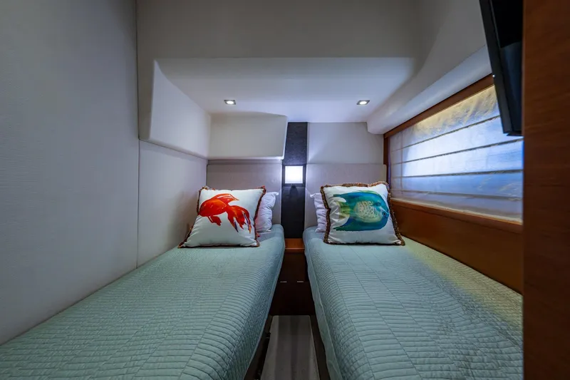 Slide: The Image of Twin beds in a 2012 Prestige Flybridge yacht cabin with decorative fish pillows. - 87