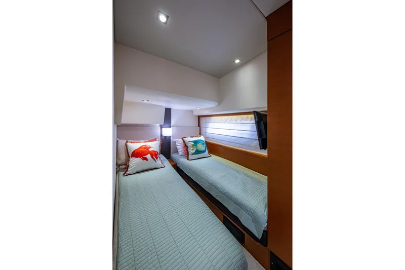 Slide: The Image of Twin beds in a 2012 Prestige Flybridge yacht cabin with decorative pillows. - 89