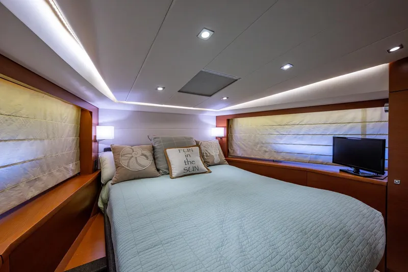 Slide: The Image of Luxurious bedroom interior of 2012 Prestige Flybridge yacht with cozy bedding and ambient lighting. - 94