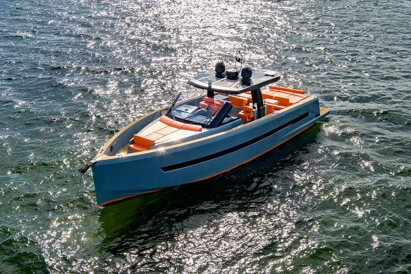 Slide: The Image of 2019 Fjord 52 Open yacht on sparkling water, featuring sleek design and vibrant orange seating. - 2