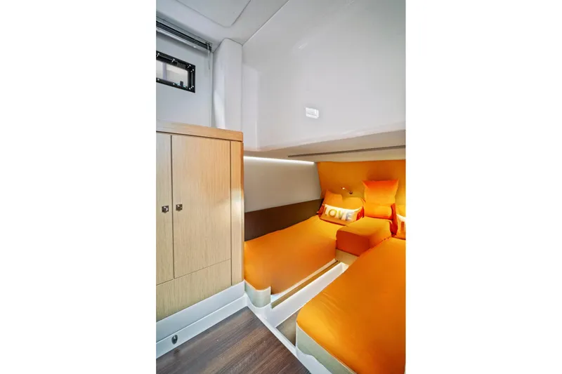 Slide: The Image of 2019 Fjord 52 Open cabin with orange bedding and wooden cabinetry. - 23