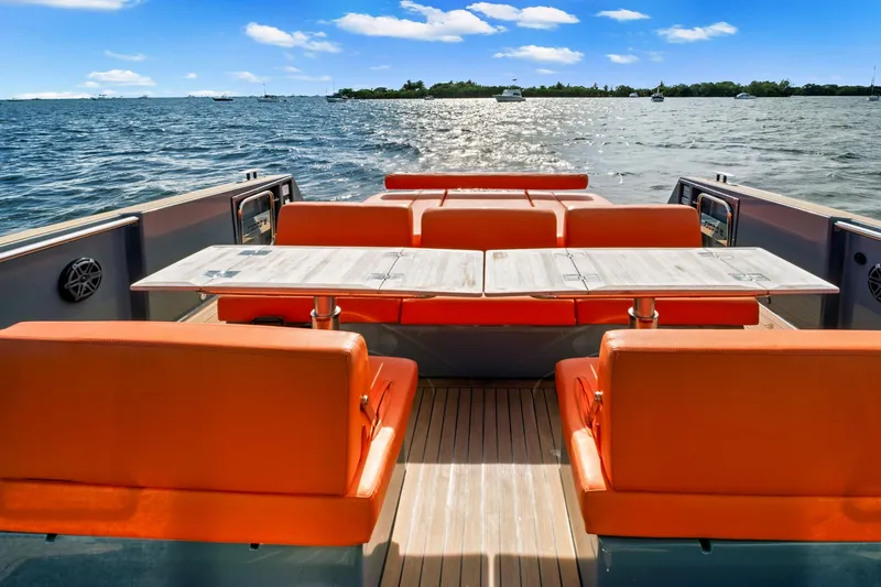 Slide: The Image of 2019 Fjord 52 Open yacht with orange seating and table on deck, ocean view. - 3