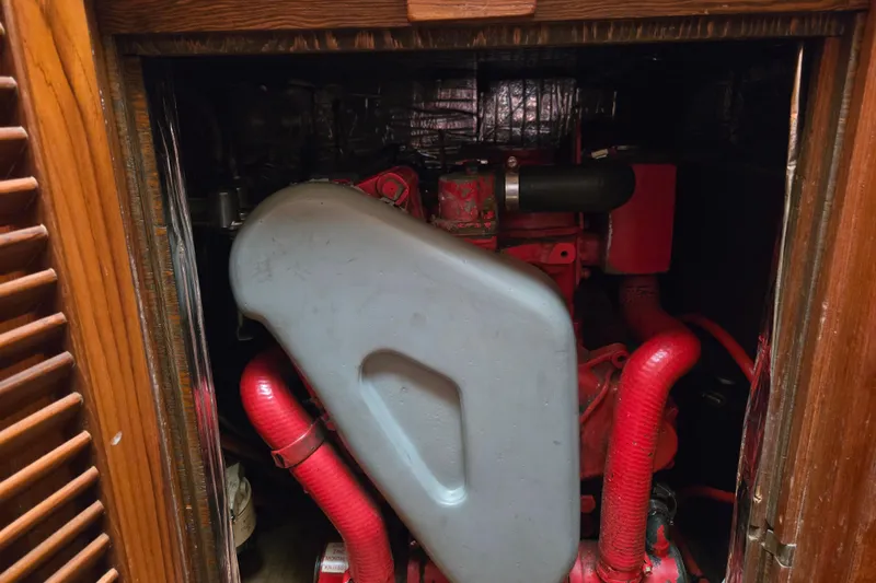 Slide: The Image of Engine compartment of a 1987 Hans Christian Cristina 40 sailboat, featuring red components. - 21