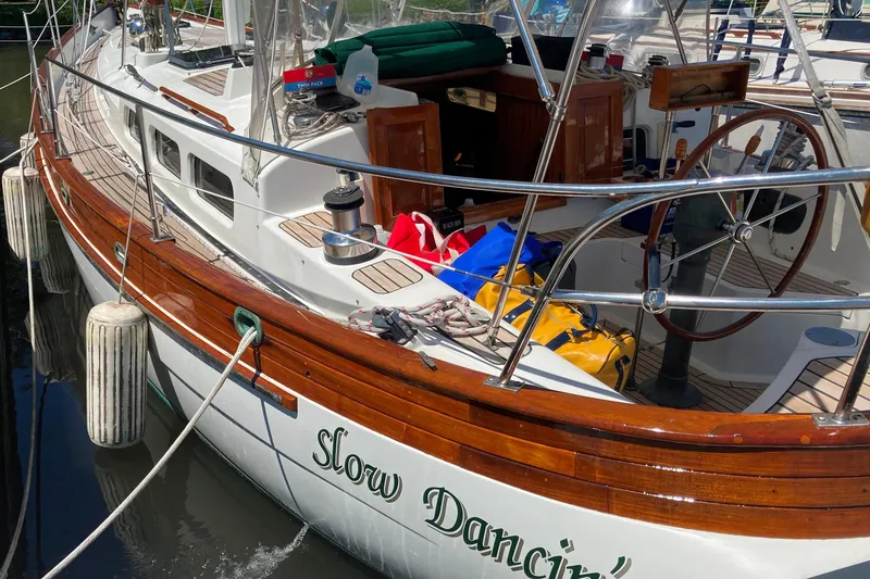 Slide: The Image of 1987 Hans Christian Cristina 40 sailboat docked, featuring wooden accents and nautical equipment. - 5