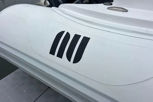 Slide: The Image of 2023 Novurania Como 18 boat with distinctive logo on white surface. - 11