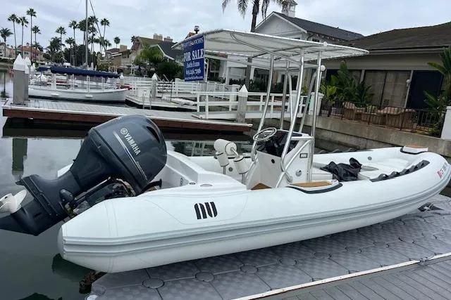 Slide: The Image of 2023 Novurania Como 18 boat docked, featuring Yamaha outboard motor, in a marina setting. - 21