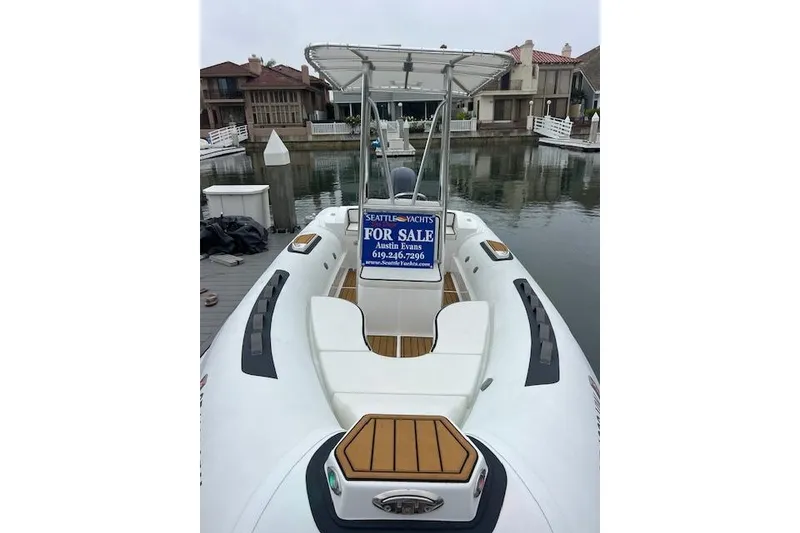 Slide: The Image of 2023 Novurania Como 18 boat for sale, docked in a marina with a "For Sale" sign. - 4