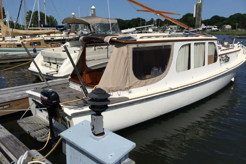 Slide: The Image of 2001 Logan 33 boat docked at marina, featuring classic design and Mercury outboard motor. - 1