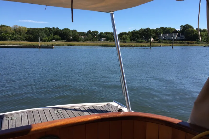 Slide: The Image of Boat deck view on calm river, surrounded by lush greenery, under clear blue sky. Logan 33, 2001. - 10