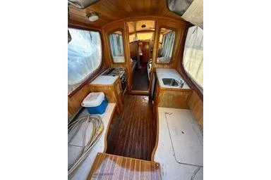 Slide: The Image of Interior of 2001 Logan 33 boat with wooden finish and compact kitchen area. - 13