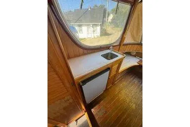 Slide: The Image of Interior of 2001 Logan 33 boat with wooden finish, sink, and mini fridge. - 19