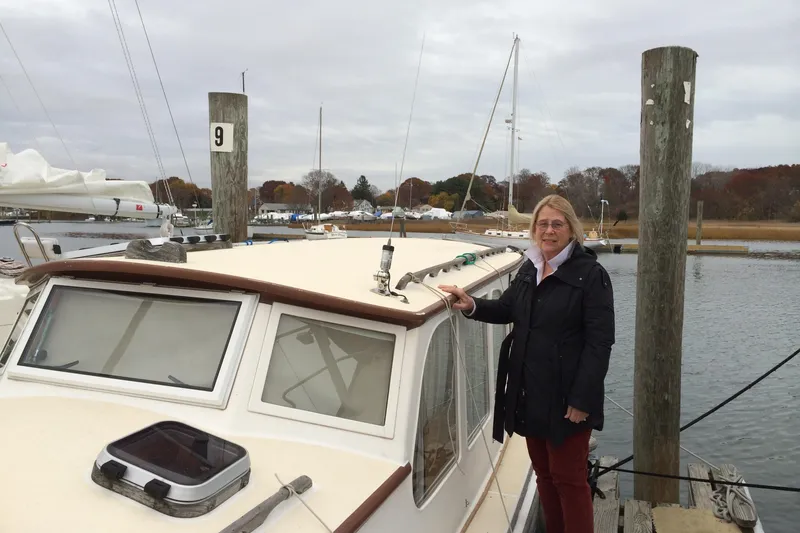 Slide: The Image of Woman standing on a 2001 Logan 33 boat docked at a marina. - 2