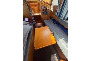 Slide: The Image of Interior of 2001 Logan 33 boat with wooden table and seating area. - 21