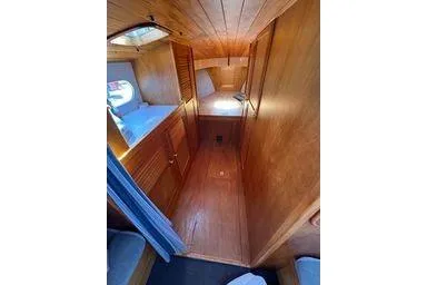 Slide: The Image of Interior of 2001 Logan 33 boat with wooden paneling and cozy sleeping area. - 22