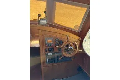 Slide: The Image of 2001 Logan 33 boat helm with wooden steering wheel and control panel. - 26