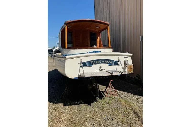 Slide: The Image of 2001 Logan 33 boat named Tangaroa, docked on land near a building. - 3