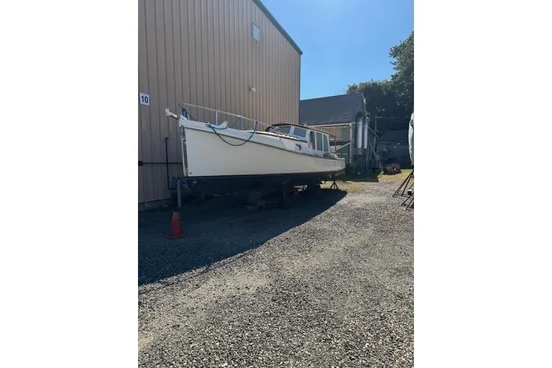 Slide: The Image of 2001 Logan 33 boat on dry dock beside a large building. - 4