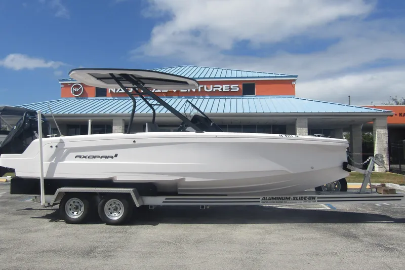 Slide: The Image of 2022 Axopar AX22TT boat on trailer, parked outside a building under a blue sky. - 5