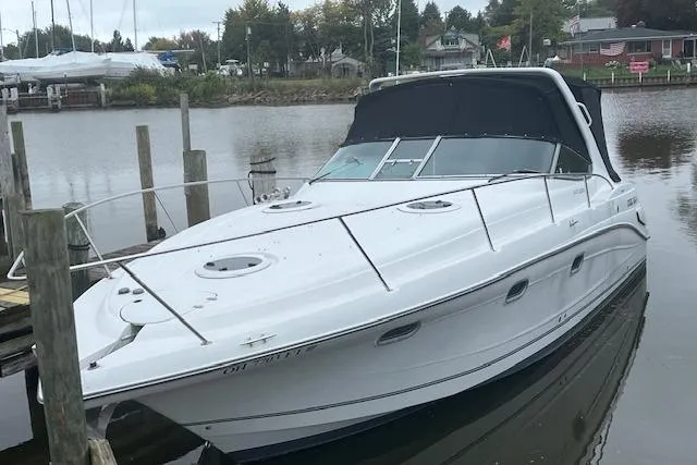 Slide: The Image of 2000 Four Winns 328 Vista boat docked in a serene marina setting. - 0