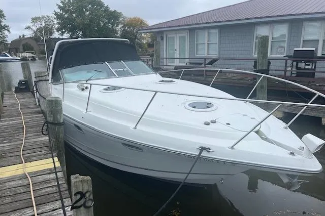 Slide: The Image of 2000 Four Winns 328 Vista boat docked near a waterfront house. - 1