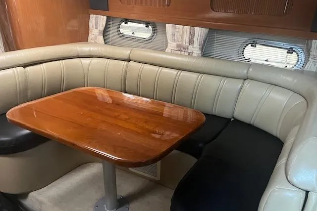 Slide: The Image of Interior of 2000 Four Winns 328 Vista boat with leather seating and wooden table. - 11