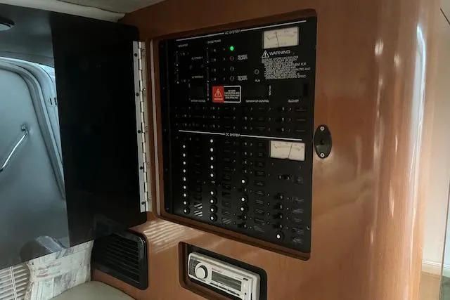 Slide: The Image of Electrical panel inside 2000 Four Winns 328 Vista boat cabin, featuring control switches and indicators. - 18