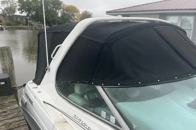 Slide: The Image of 2000 Four Winns 328 Vista boat docked with black canopy cover. - 2