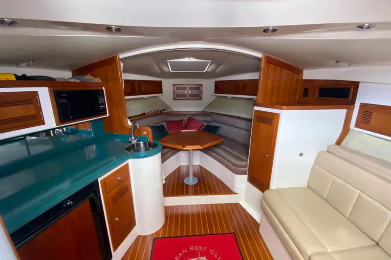 Slide: The Image of Interior of a 1996 Cabo 31 Express boat with kitchenette and seating area. - 11