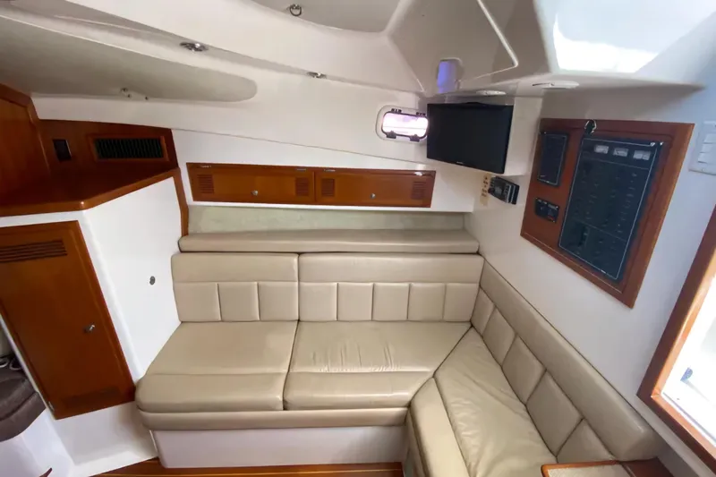 Slide: The Image of Interior of a 1996 Cabo 31 Express boat with beige seating and wooden accents. - 13