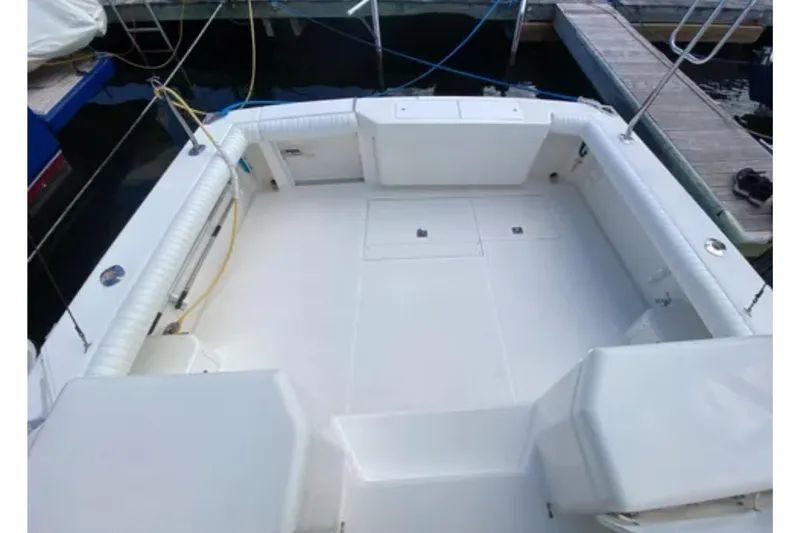 Slide: The Image of 1996 Cabo 31 Express boat deck, spacious and clean, docked at marina. - 4