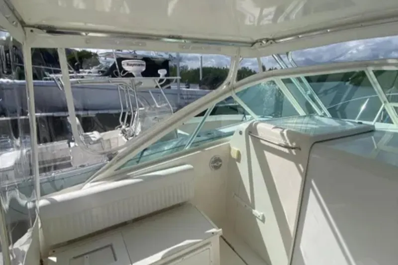 Slide: The Image of 1996 Cabo 31 Express boat interior with white seating and clear windows. - 7