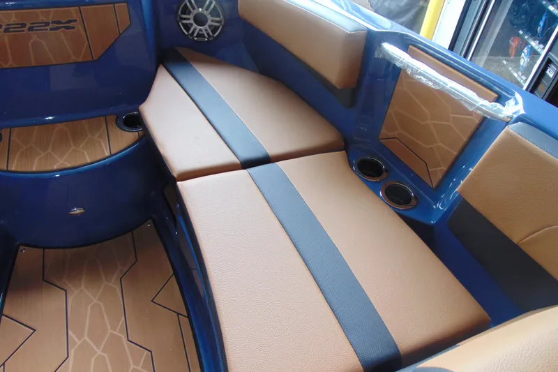 Slide: The Image of 2026 Yamaha Boats 222XD interior with tan and black seating, cup holders, and speaker. - 19