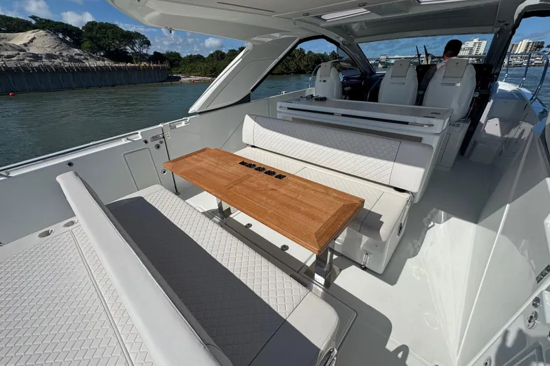 Slide: The Image of 2024 Jeanneau DB43 yacht interior with elegant seating and wooden table on a sunny day. - 19