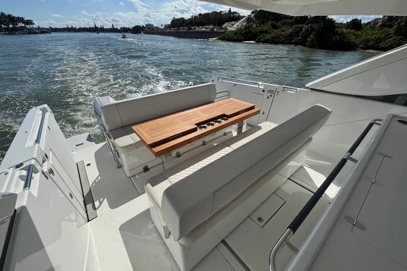 Slide: The Image of 2024 Jeanneau DB43 yacht with elegant seating and wooden table on open water. - 20